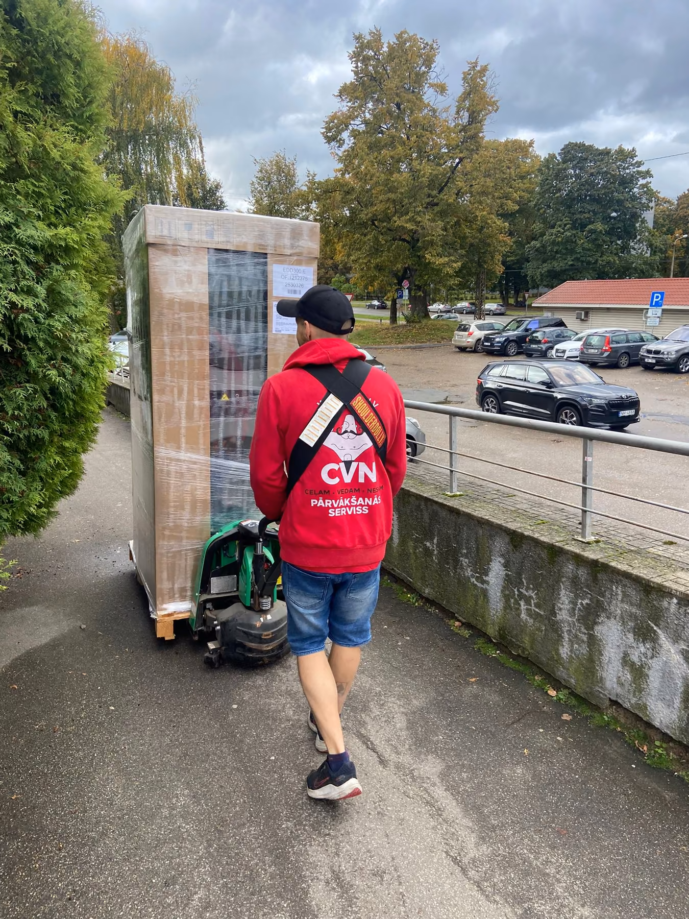 Delivering a wrapped fridge on a dolly